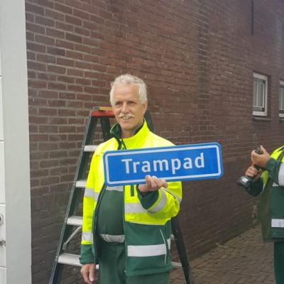 2 medewerkers van gemeente hangen naambordje 'Trampad' op